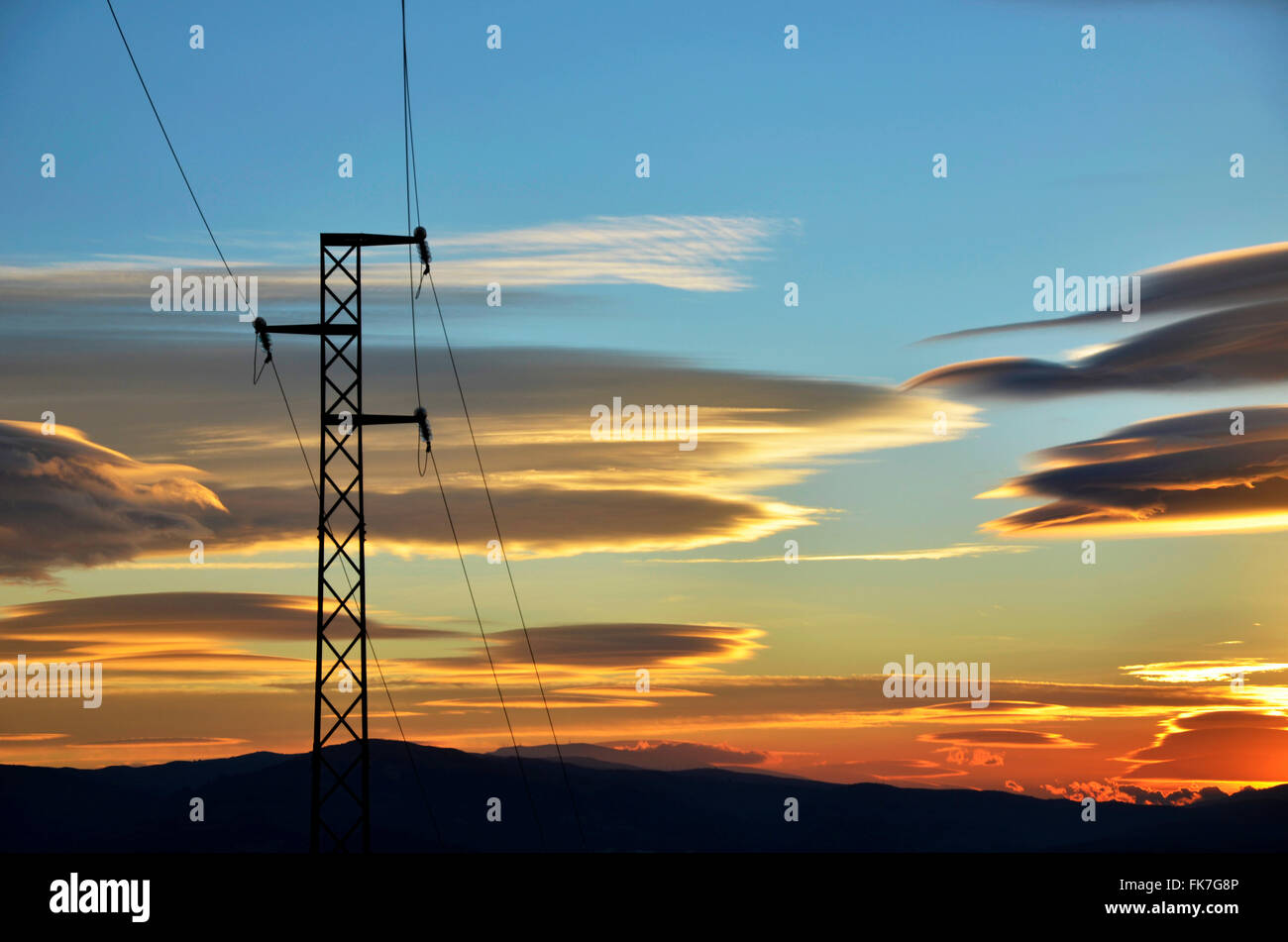 Polo elettrico di linee di alimentazione e i cavi al tramonto Foto Stock