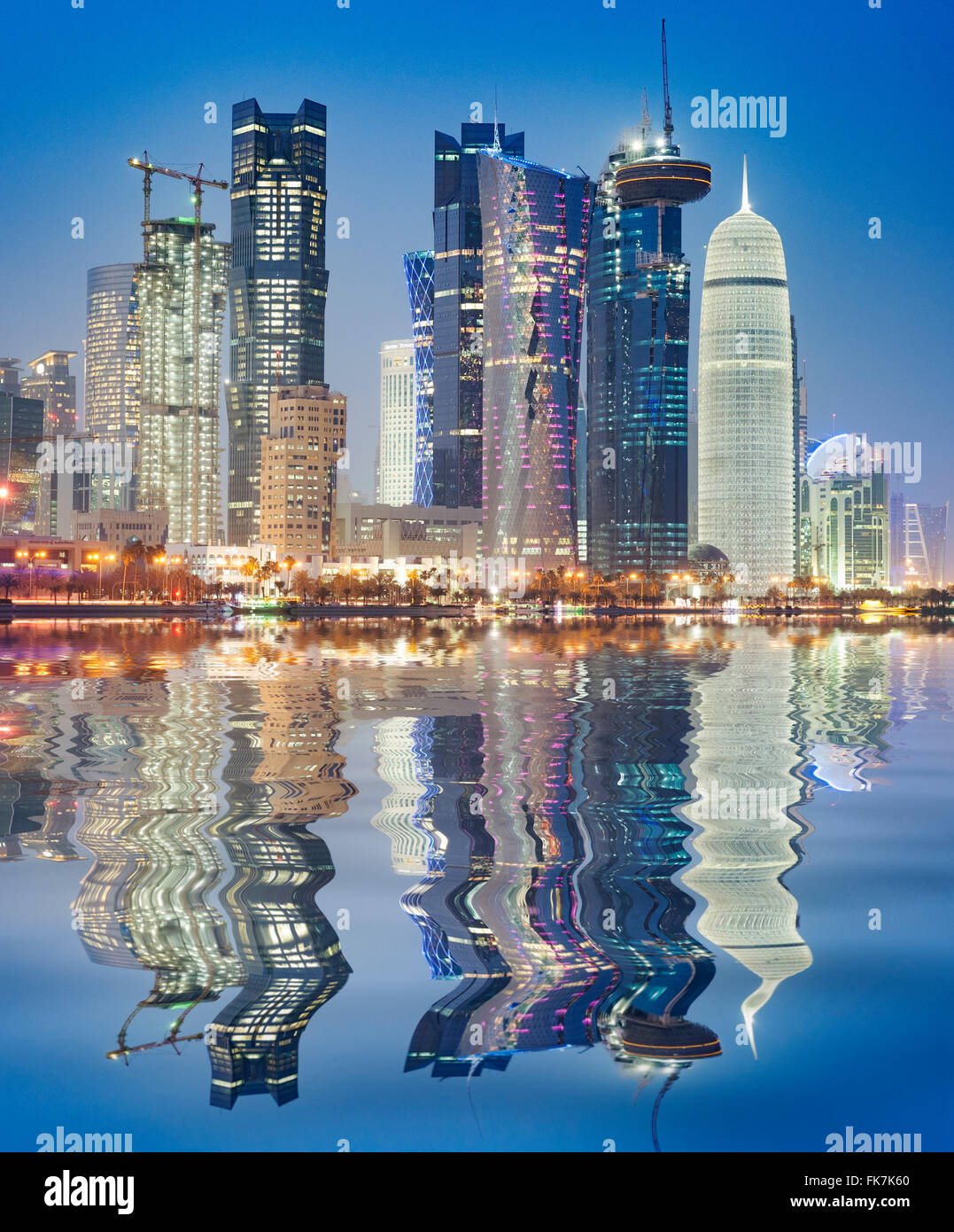 Vista notturna della skyline lungo il lungomare di Corniche verso moderne torri di uffici a Doha in Qatar Foto Stock