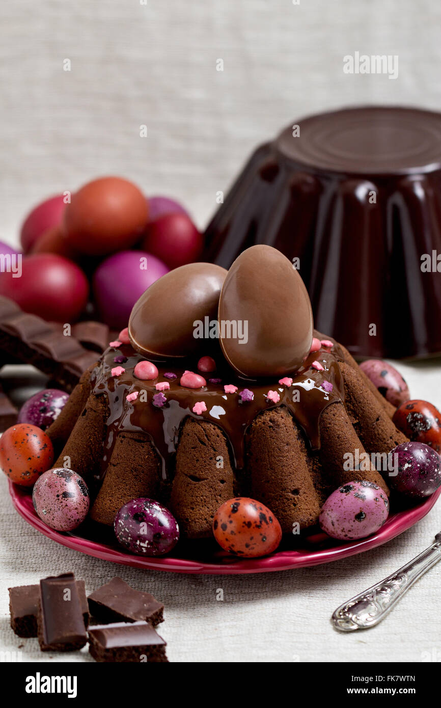 Cioccolato torta di Pasqua e uova di Pasqua colorate in viola e marrone. Messa a fuoco selettiva. Foto Stock