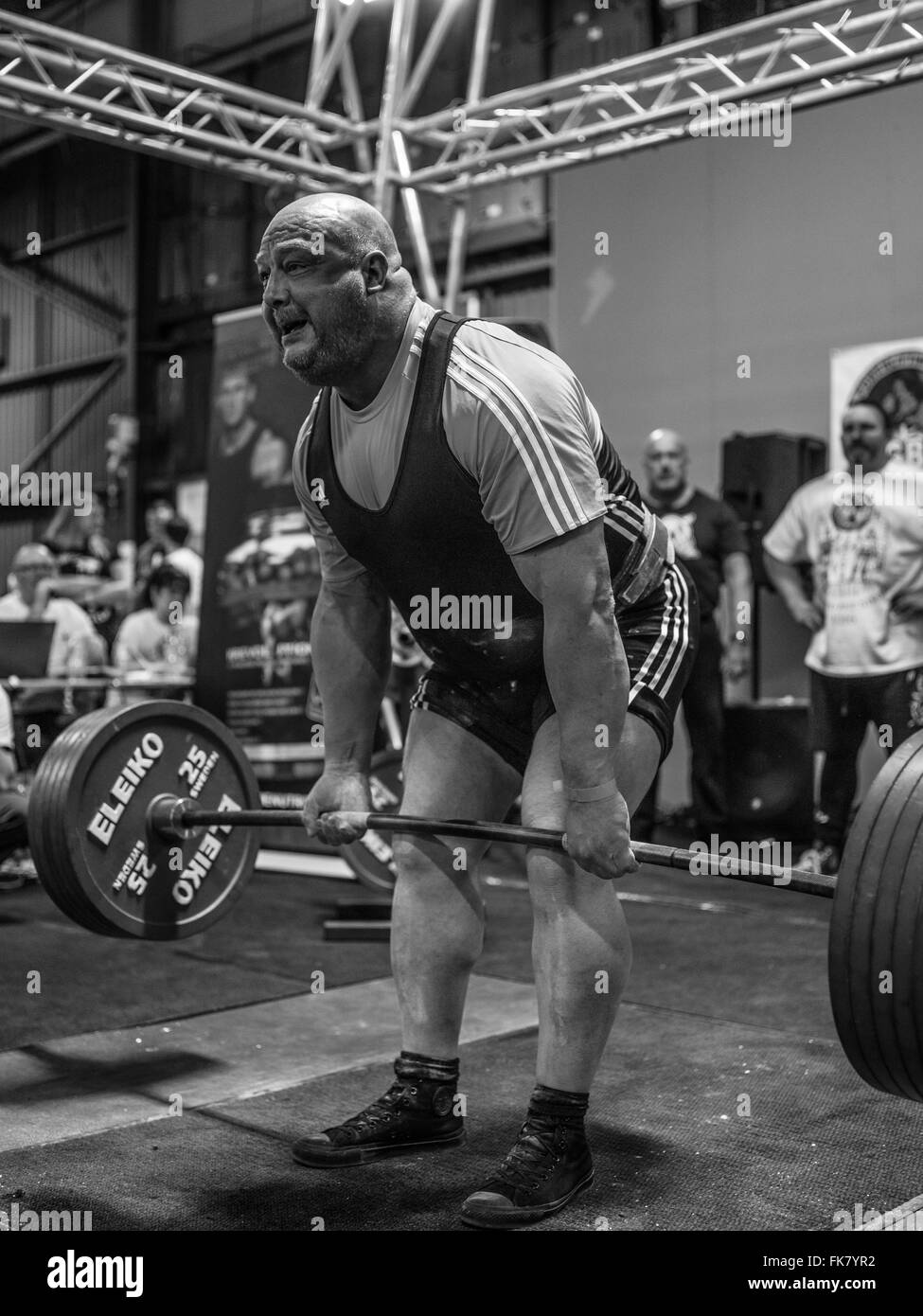 Fotografia documentaria dalla potenza di un evento di sollevamento dotata di uomini deadlifting e panca premendo e vivendo il trionfo e lo stress Foto Stock
