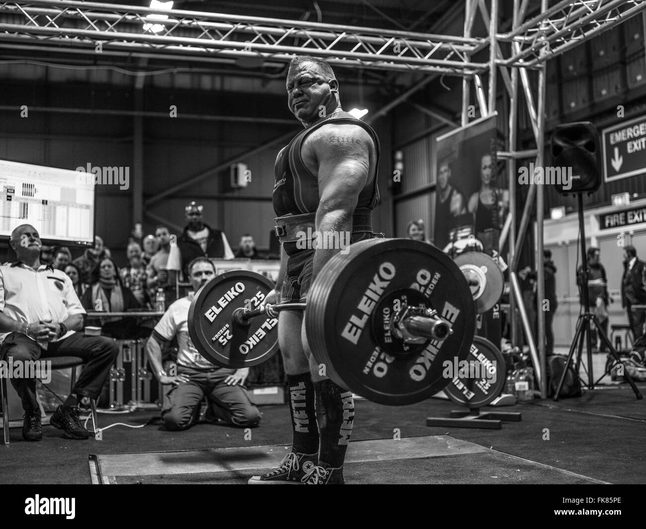 Fotografia documentaria dalla potenza di un evento di sollevamento dotata di uomini deadlifting e panca premendo e vivendo il trionfo e lo stress Foto Stock