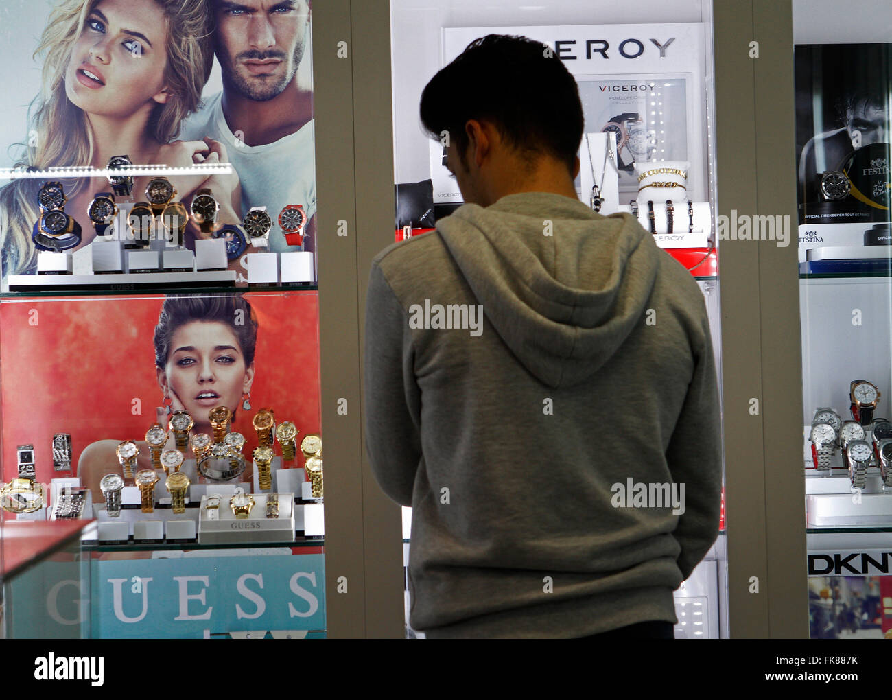 Uomo che guarda gli orologi in un negozio durante il Venerdì nero. In una giornata aperta e molto affollato. Foto Stock