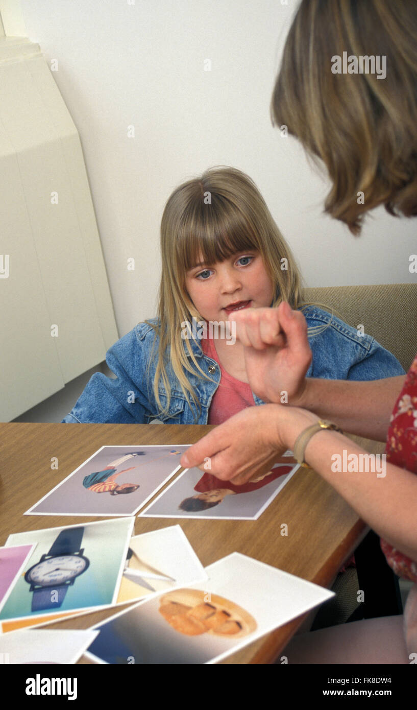 Logopedista e giovane ragazza in terapia camera utilizzando il linguaggio dei segni Foto Stock