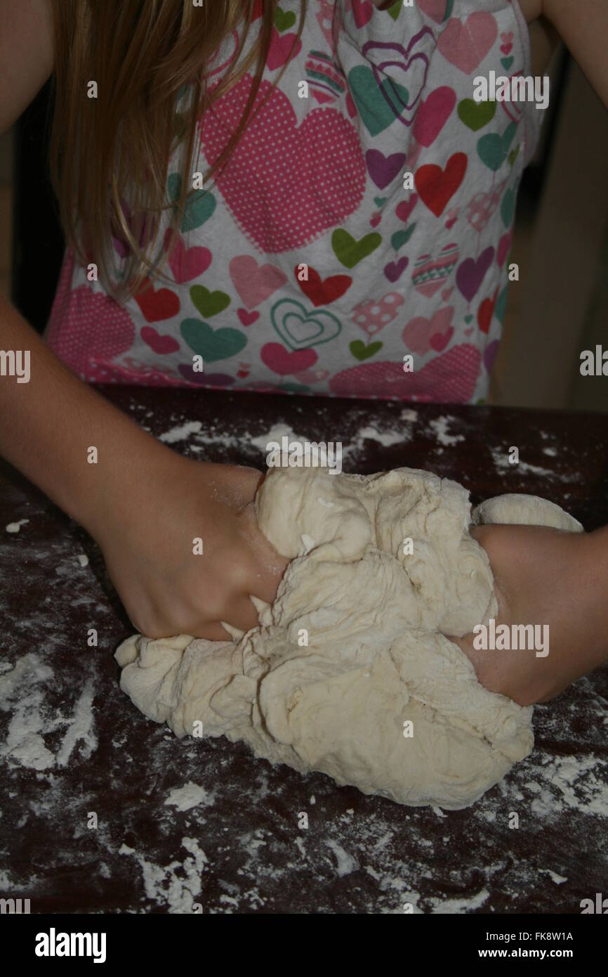 Ragazza giovane impastare la pasta di pane Foto Stock
