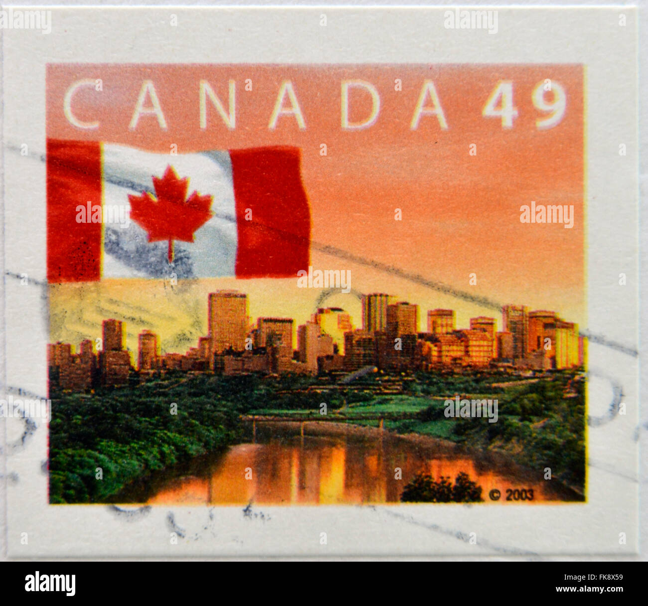CANADA - circa 2003: un timbro stampato in Canada mostra bandiera contro lo sfondo della città di Edmonton skyline all'alba Foto Stock