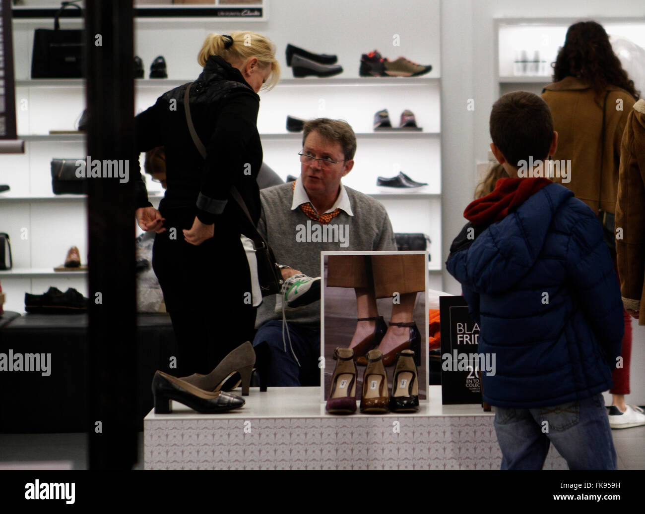 Le persone in cerca di scarpe in un negozio durante il Venerdì nero. In una giornata aperta e molto affollato. Foto Stock