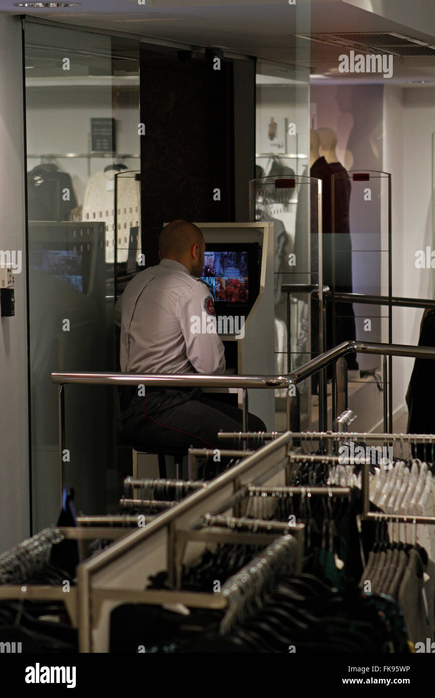 La guardia di sicurezza la visione di un negozio di abbigliamento da schermo durante il Venerdì nero. In una giornata aperta e molto affollato. Foto Stock