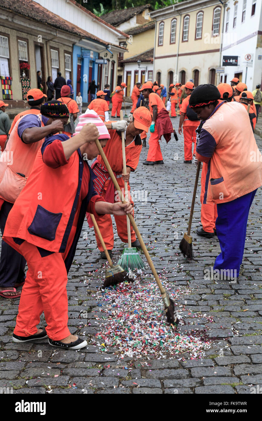 I garbage collector pulizia della strada dopo il passaggio della processione del Corpus Domini Foto Stock