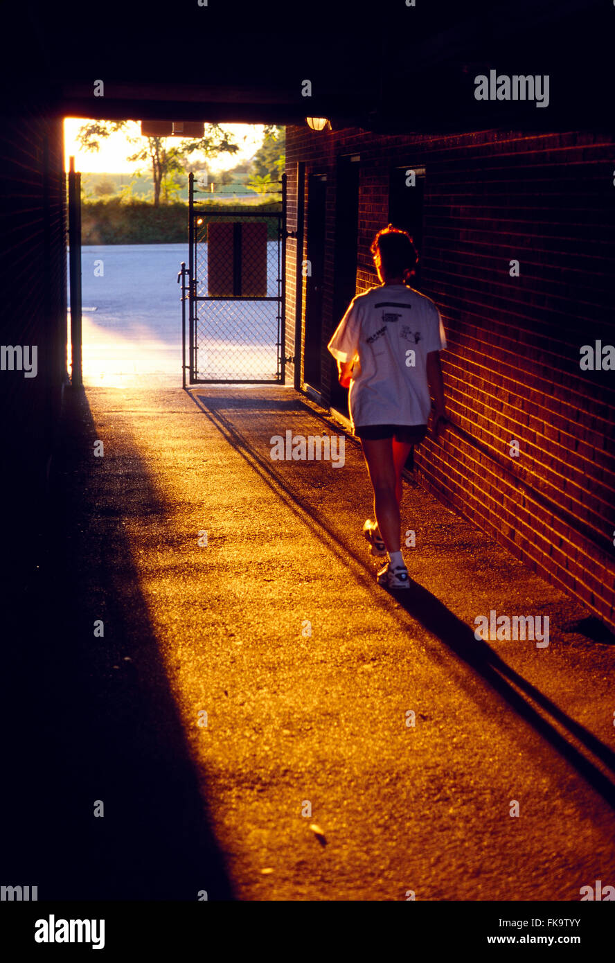Si illumina al tramonto femminile lasciando stadium via attraverso il tunnel Foto Stock