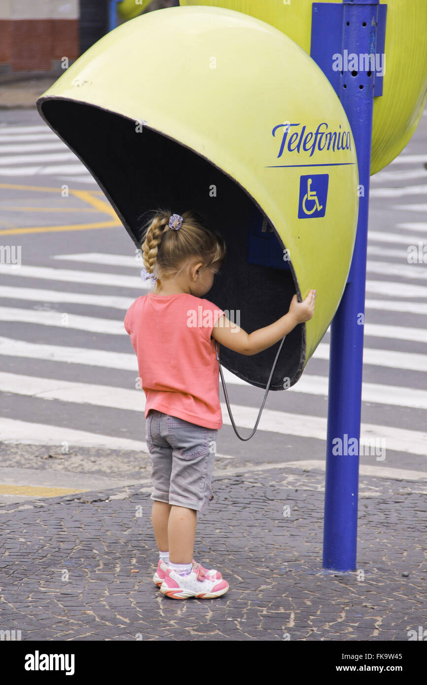Il bambino nel telefono pubblico in Praca Visconde de Indaiatuba centro città Foto Stock
