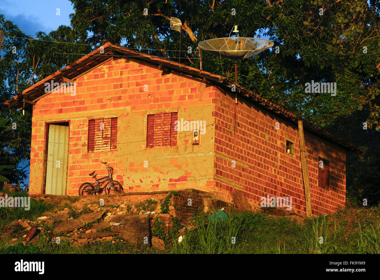 Casa semplice con antenna parabolica nel tardo pomeriggio Foto Stock