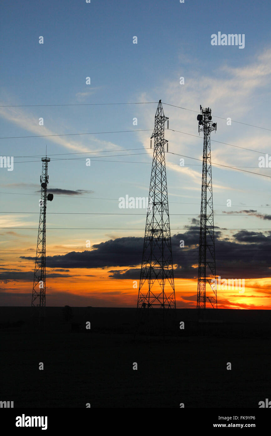 Le torri di trasmissione di energia elettrica e di telecomunicazioni nel tardo pomeriggio Foto Stock