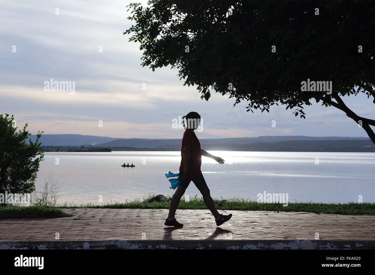 Persona che cammina sul bordo del lago Tocantins nel tardo pomeriggio Foto Stock