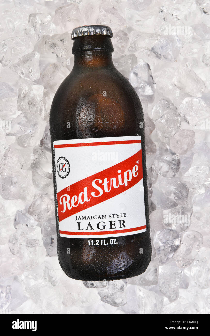 Una bottiglia di Red Stripe Lager giamaicano su un letto di ghiaccio. Formato verticale. Foto Stock