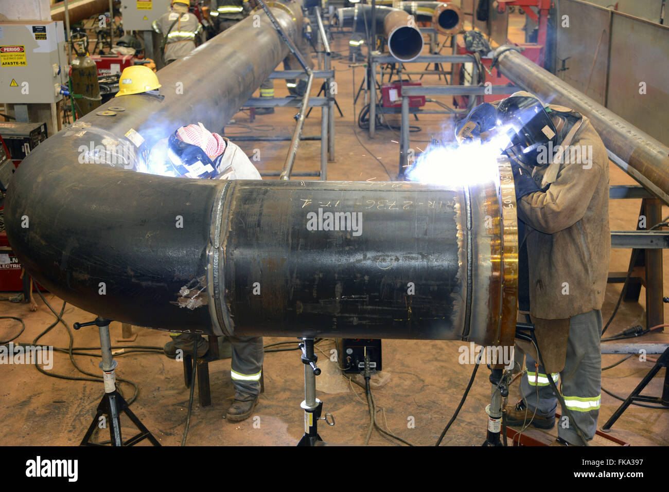 La saldatura di tubazioni nel lavoro di costruzione di fertilizzante azotato unità Foto Stock