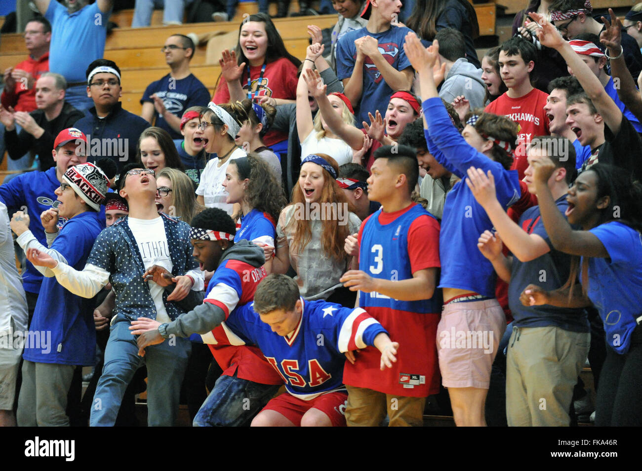 Sezione studenti ad una high school boys basketball playoff gioco reagisce agli eventi sulla corte con una varietà di emozioni. Stati Uniti d'America. Foto Stock