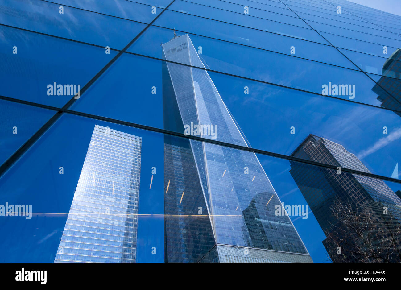 La Freedom Tower e altri World Trade Center grattacieli si riflette nella superficie di vetro del 9/11 Memorial Building in NYC Foto Stock