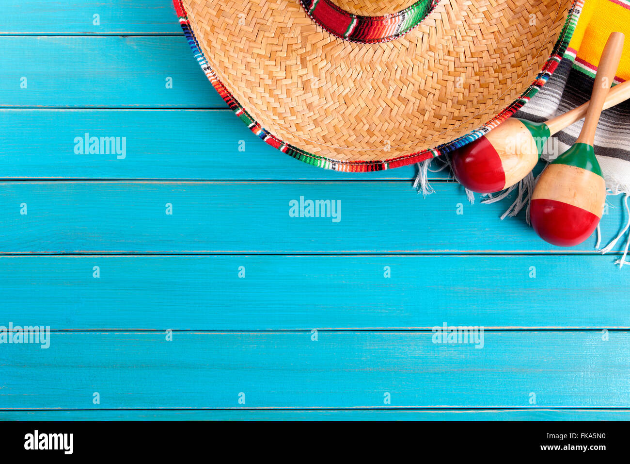 Sombrero messicano e maracas con tradizionale serape coperta prevista su un vecchio blu dipinta in legno di pino piano. Spazio per la copia. Foto Stock