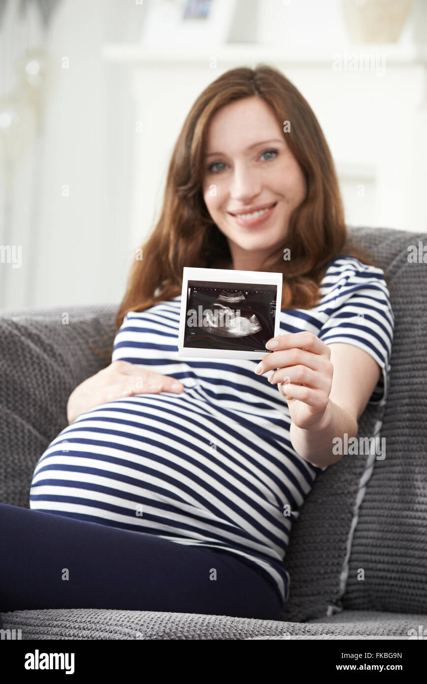 Ritratto Di Donna Incinta Holding di scansione ad ultrasuoni del bambino Foto Stock