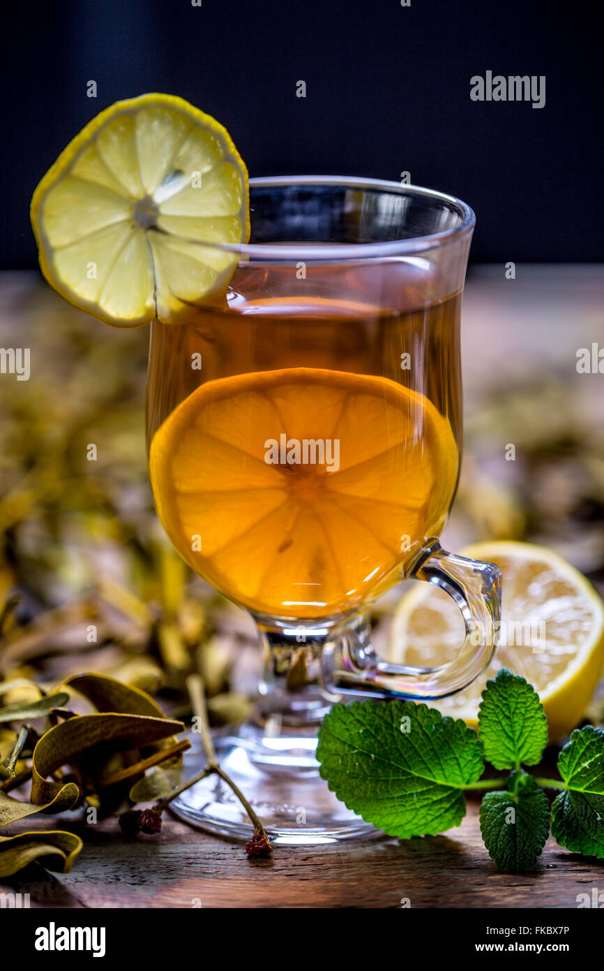 Tazza di tè alle erbe con limone rustico sfondo di legno Foto Stock