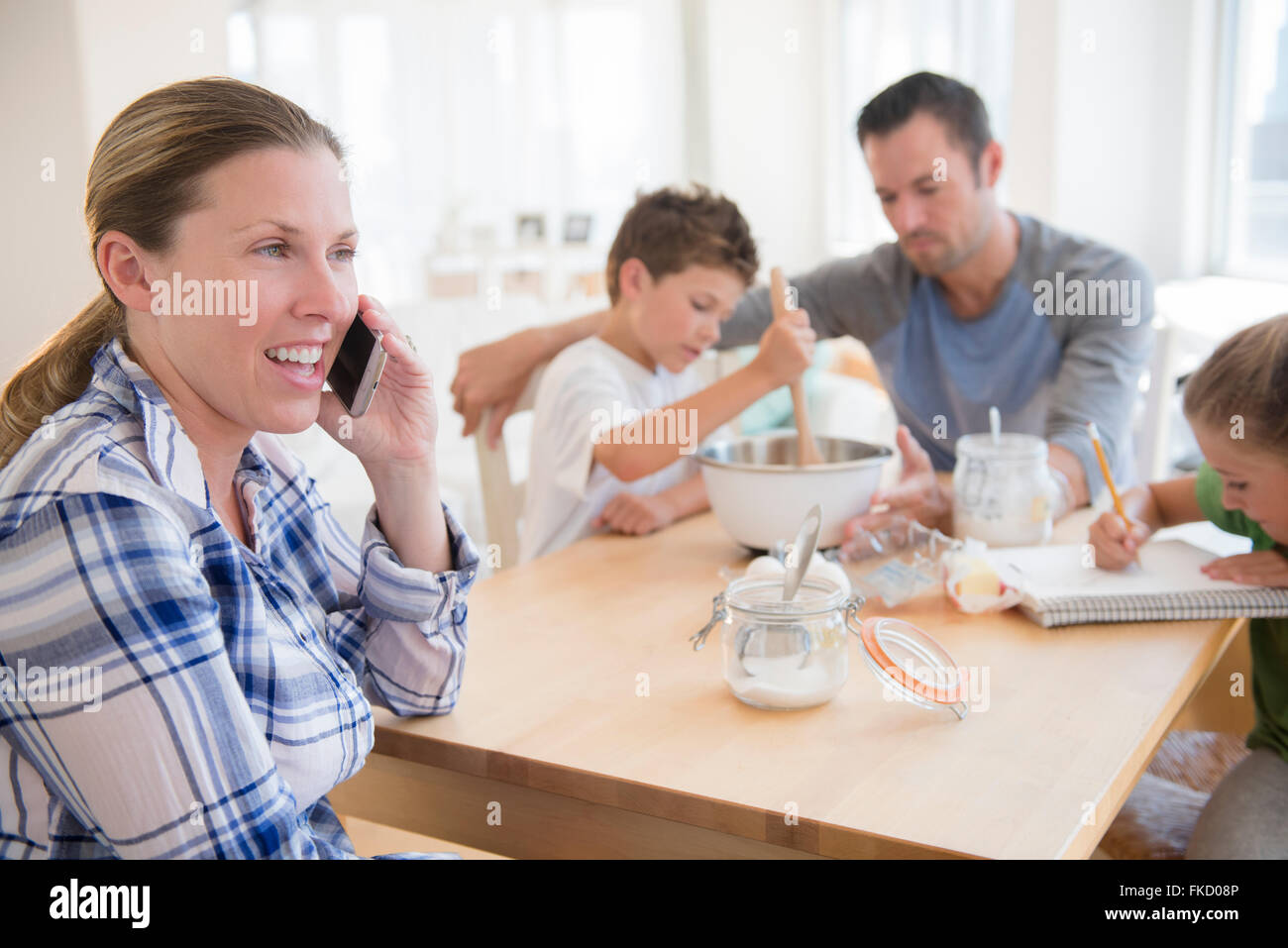 Famiglia con due bambini (6-7, 8-9) seduta a tavola Foto Stock