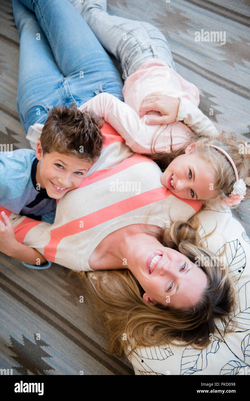 Madre sdraiato con il figlio (8-9) e la figlia (6-7) Foto Stock