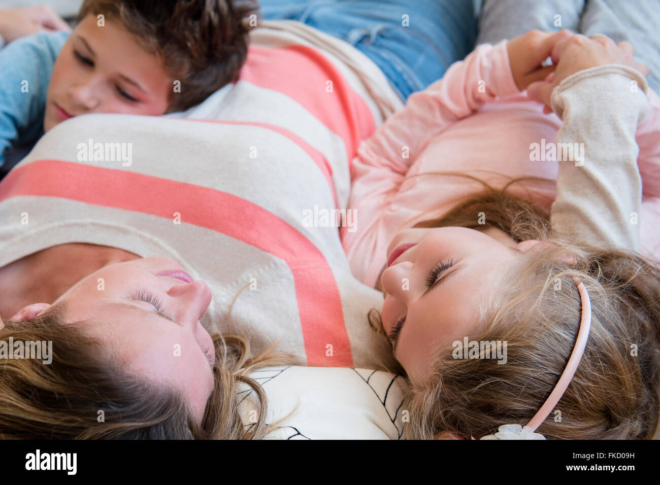Madre sdraiato con il figlio (8-9) e la figlia (6-7) Foto Stock
