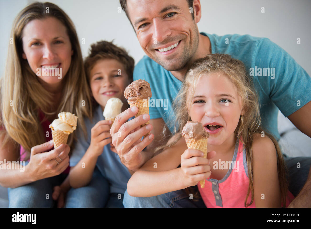 Famiglia con due bambini (6-7, 8-9) azienda coni gelato Foto Stock