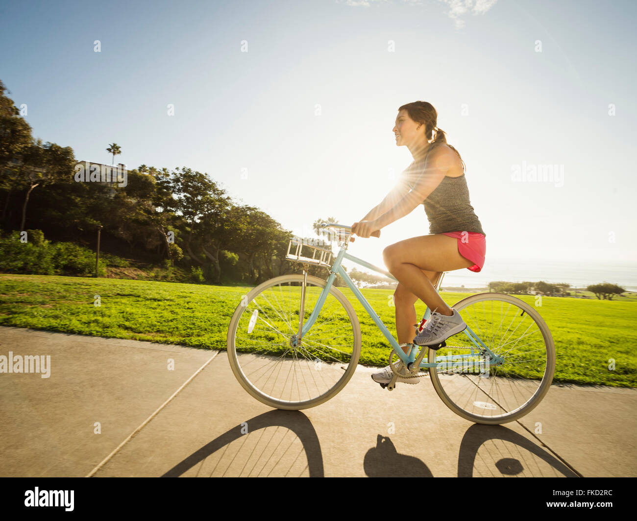 Giovane donna in bicicletta nel parco Foto Stock