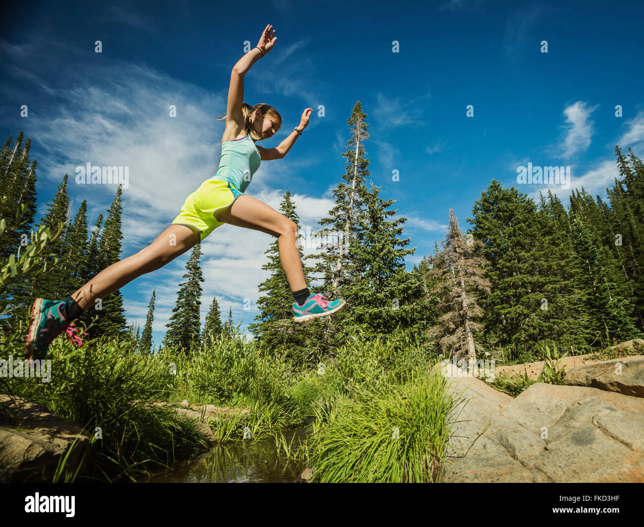 Ragazza adolescente (14-15) jumping in foresta Foto Stock