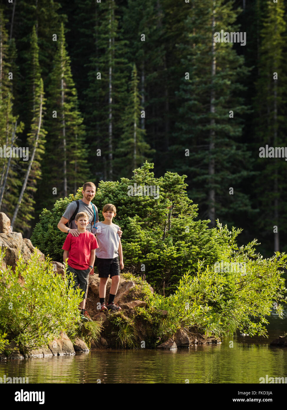Padre con figli (10-11, 12-13) dal lago Foto Stock