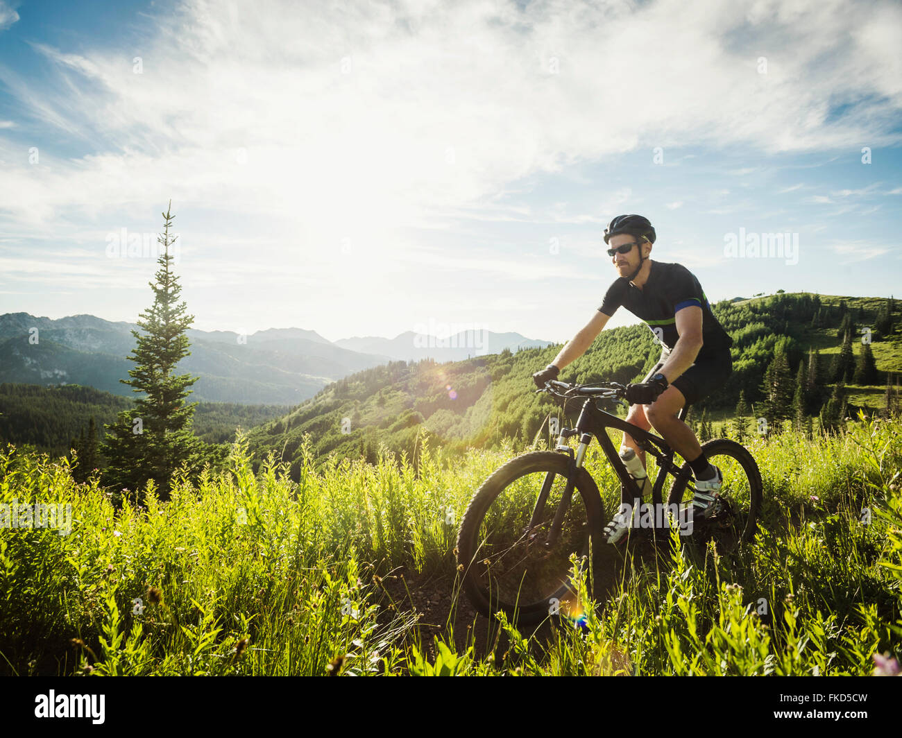 L'uomo durante il viaggio in bicicletta nel paesaggio di montagna Foto Stock