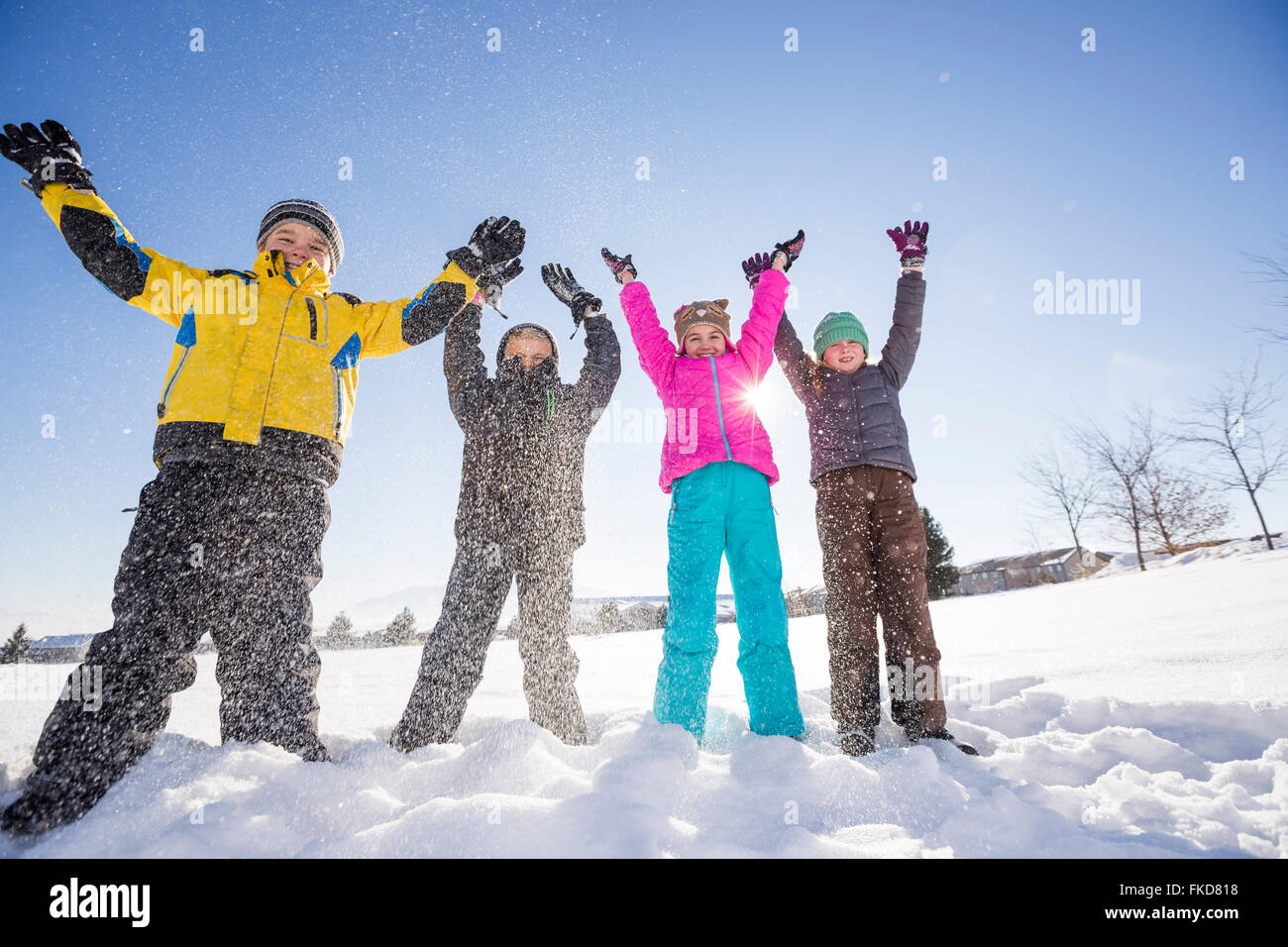 Bambini (8-9, 10-11) in piedi nella neve con le braccia sollevate Foto Stock