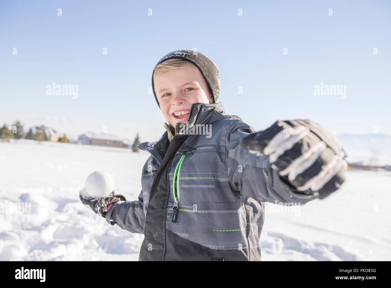 Ragazzo (8-9) lanciando palle di neve Foto Stock