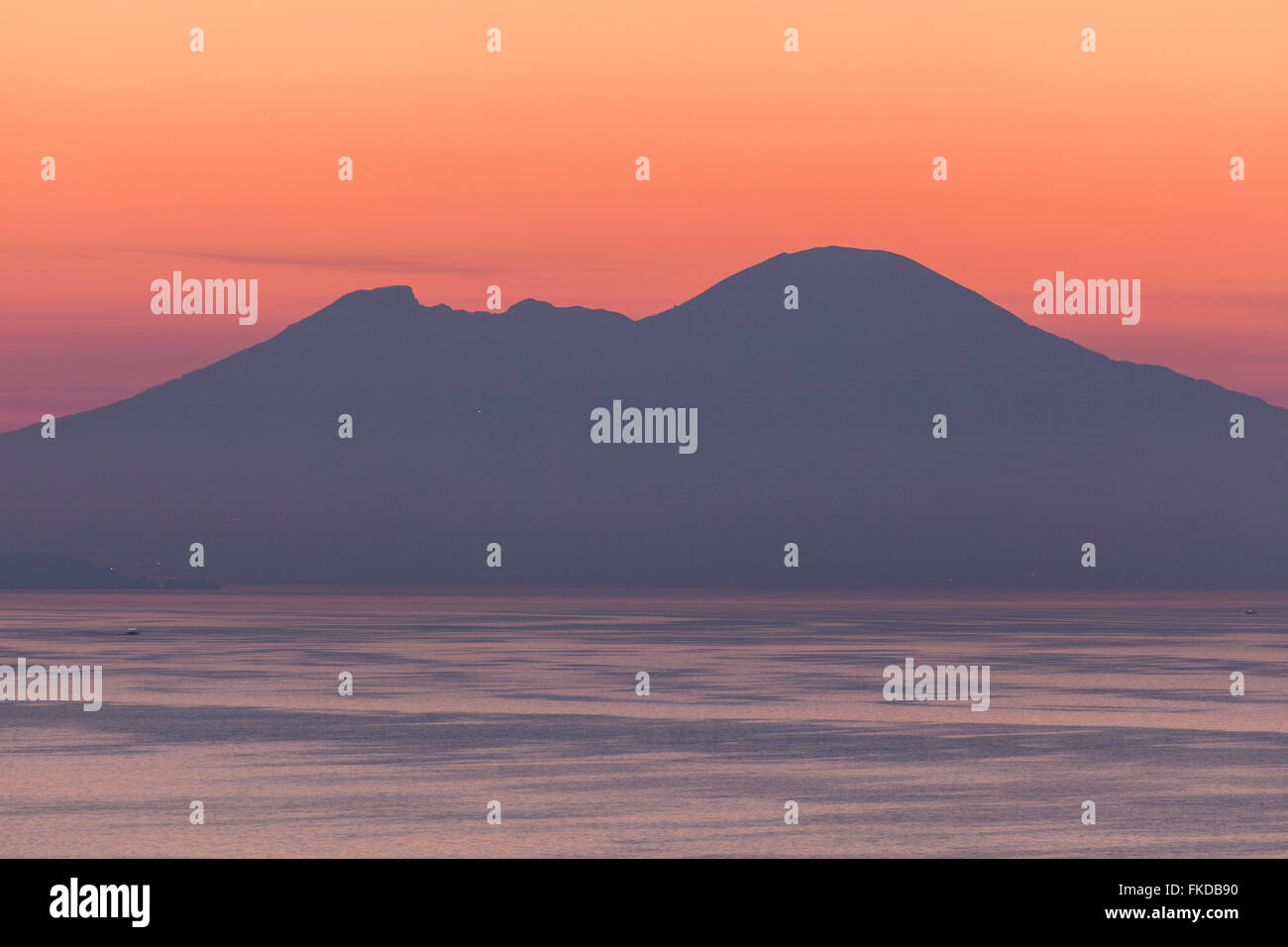 Silhouette di montagna con mare in primo piano al tramonto Foto Stock