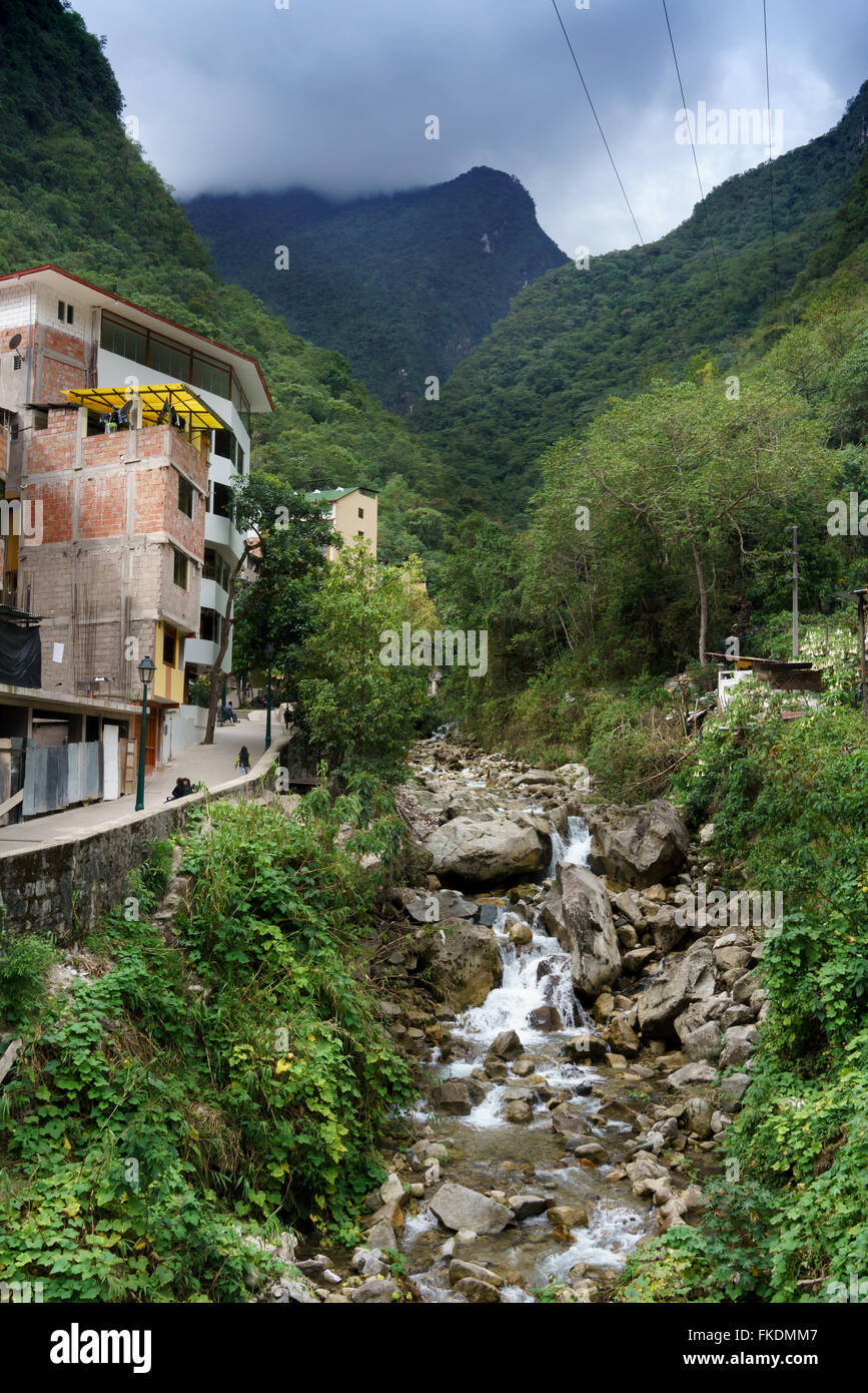 Con flusso di case contro la gamma della montagna, Machu Picchu Cusco, Regione, Provincia di Urubamba, Machupicchu distretto, Perù Foto Stock