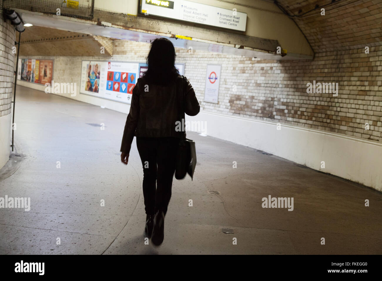 Una donna che cammina da sola in una metropolitana, la metropolitana di Londra a South Kensington, London REGNO UNITO Foto Stock