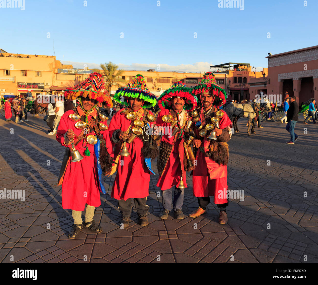 Guerrab o portatori di acqua in abiti tradizionali con sacchi di acqua e ciotole di ottone sul giocolieri piazza Djemaa el Fna Foto Stock