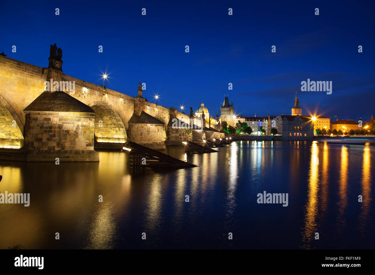 Vista di notte attraverso il fiume Moldava a Praga con il ponte Carlo San Francesco Chiesa Foto Stock
