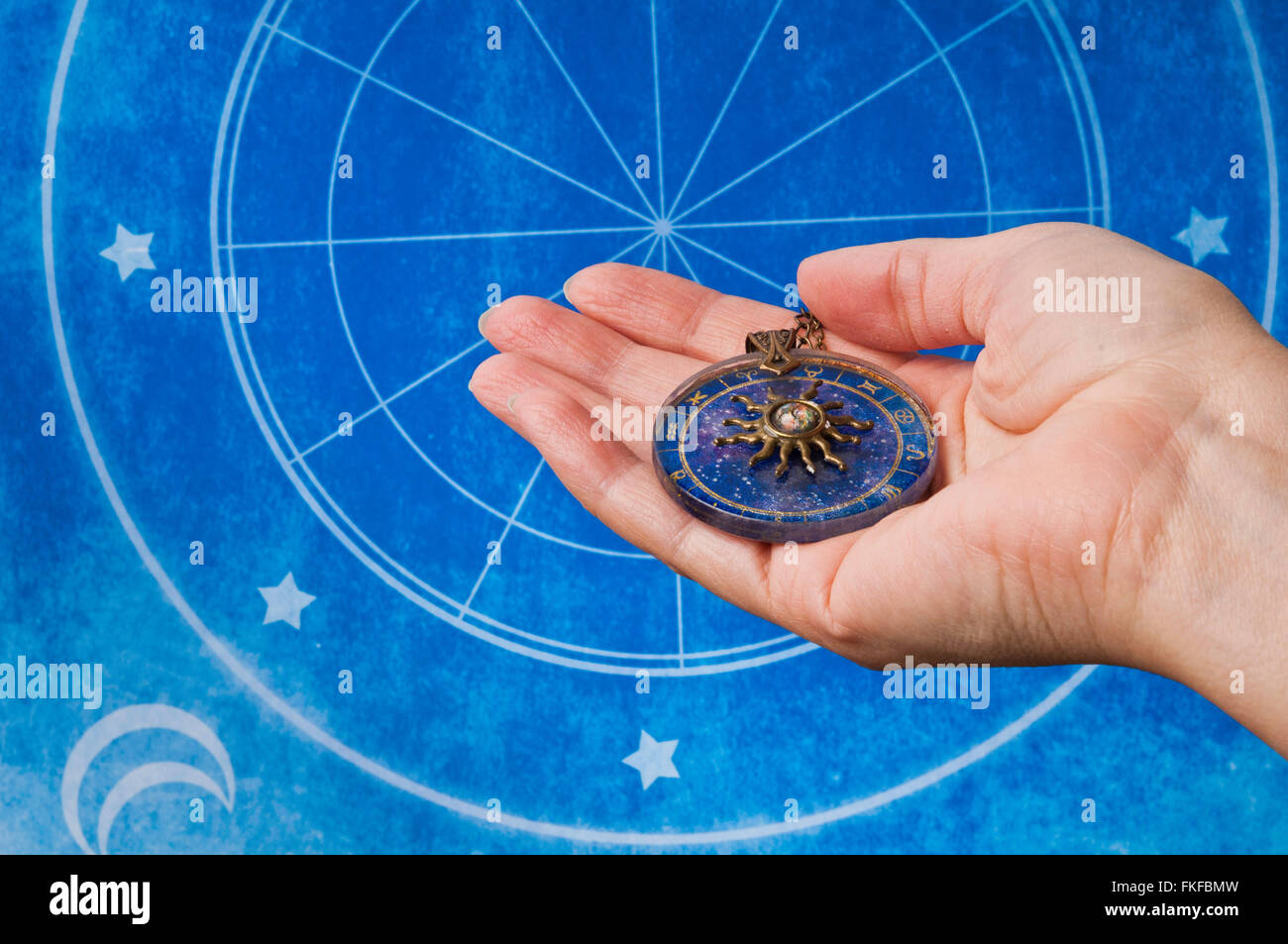 Donna mano che regge un medaglione astrologia Foto Stock