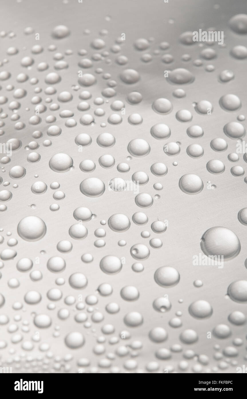 Gocce di acqua sulla superficie di metallo, macro Foto Stock