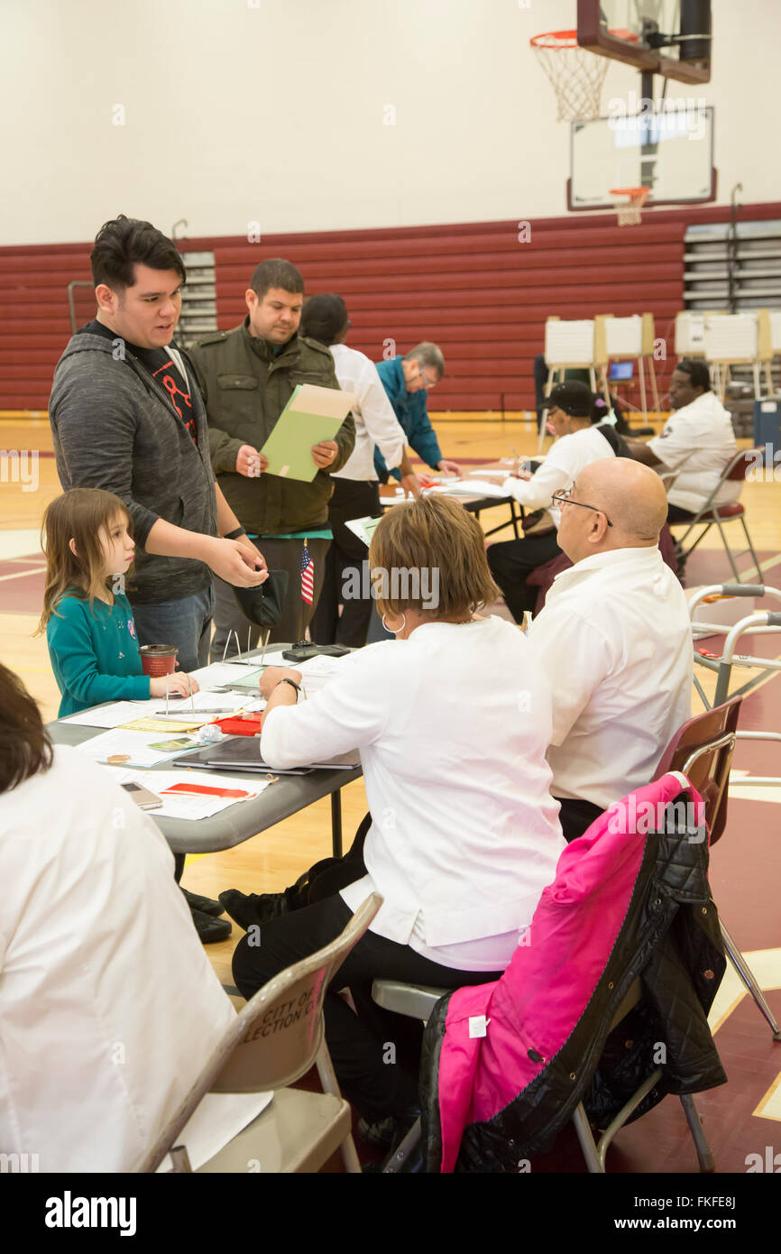 Detroit, Michigan, Stati Uniti d'America. 8 Marzo, 2016. Un uomo attende di ottenere il suo turno di scrutinio per Michigan primaria dell elezione presidenziale come sua figlia orologi. Credito: Jim West/Alamy Live News Foto Stock