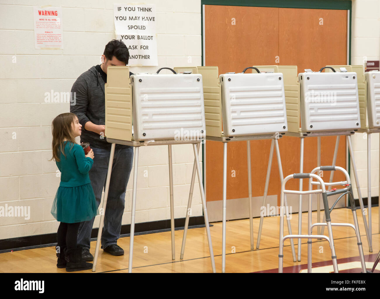 Detroit, Michigan, Stati Uniti d'America. 8 Marzo, 2016. Una ragazza guarda come suo padre voti in Michigan primaria dell elezione presidenziale. Credito: Jim West/Alamy Live News Foto Stock