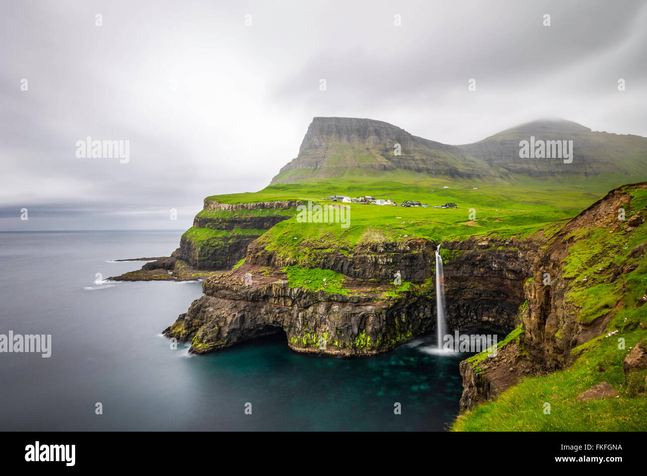 Gasadalur villaggio e la sua leggendaria cascata, funzionario ministeriale, Isole Faerøer, Danimarca. Lunga esposizione. Foto Stock