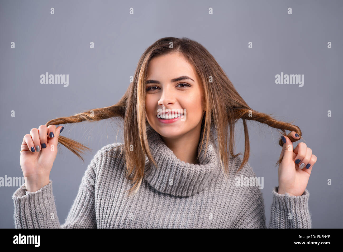 Ragazza sorridente arricciare i capelli Foto Stock