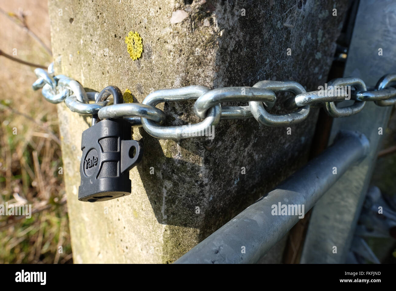 Il lucchetto e la catena intorno un gatepost Foto Stock