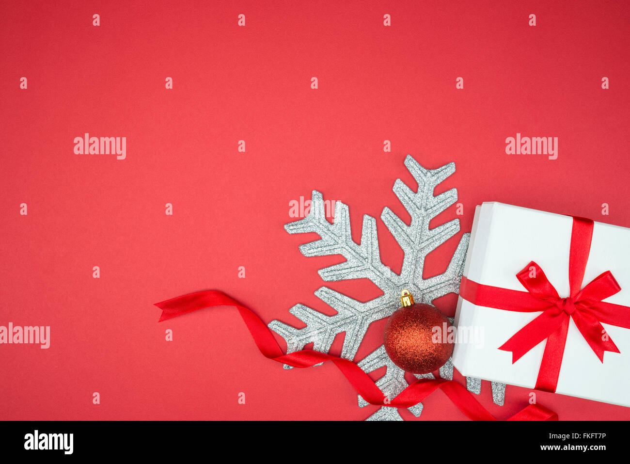 Elegante confezione regalo per le feste evento wrap seta sfera di fiocco di neve su sfondo rosso isolato Foto Stock