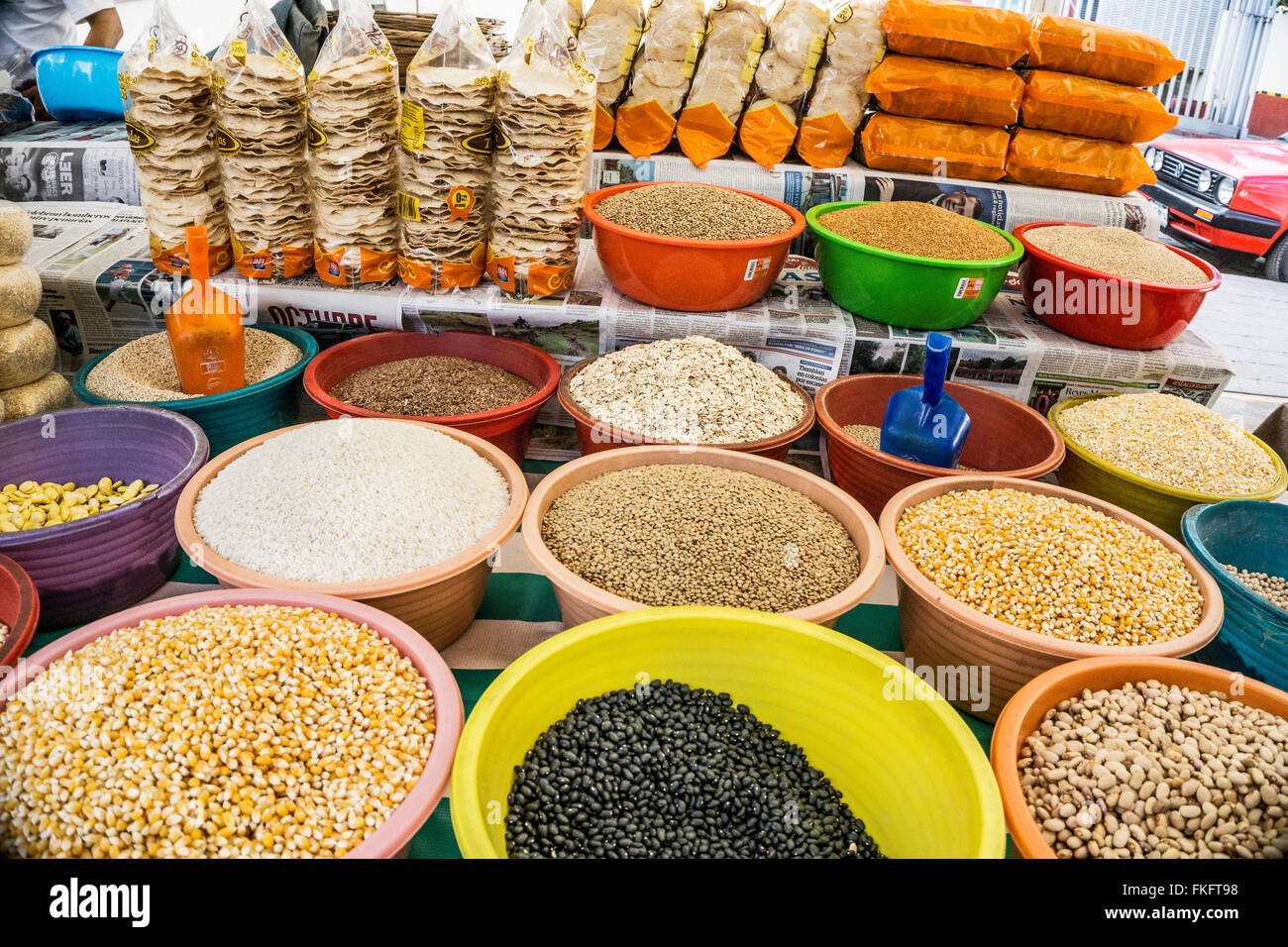 Display a colori luminoso ciotole di plastica contenente molte varietà di cereali e sementi e pacchetti di cellophane piccole tortillas croccanti Foto Stock