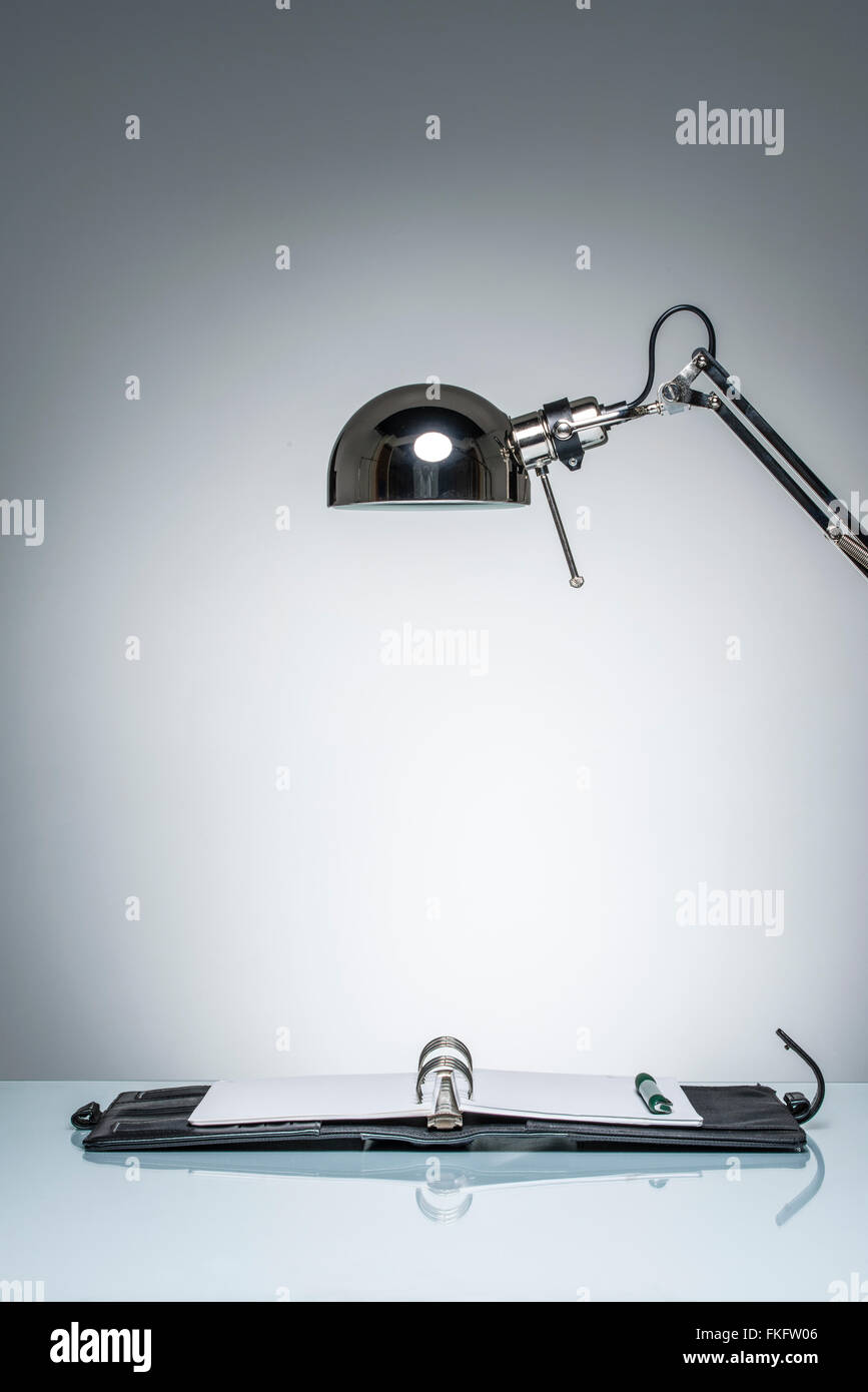 Accensione diario di notebook la scrittura con una lampada da scrivania sul round illuminazione da studio Foto Stock