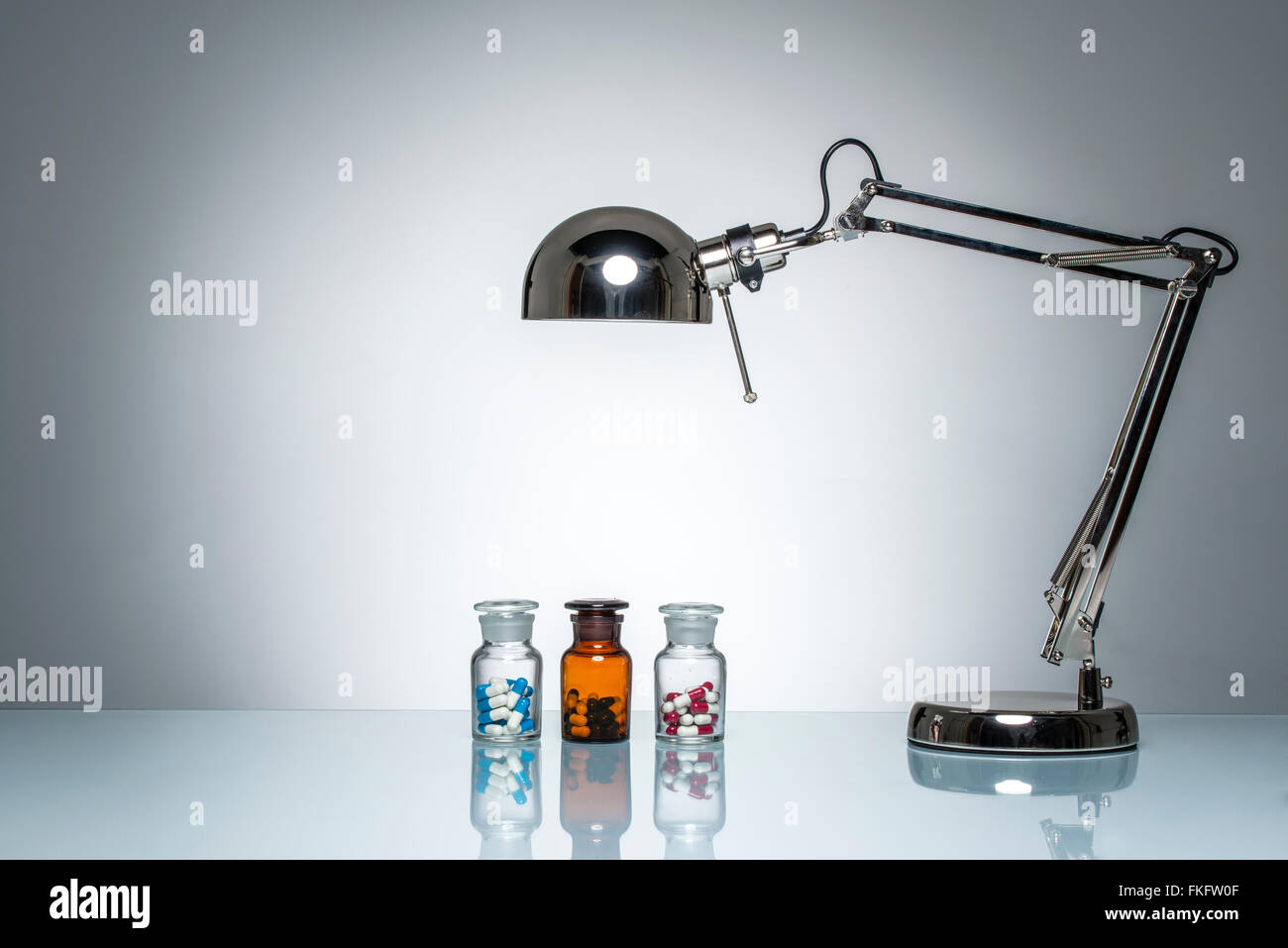 Illuminazione di bottiglia farmaci medicina pillola con una lampada da scrivania sul round illuminazione da studio Foto Stock